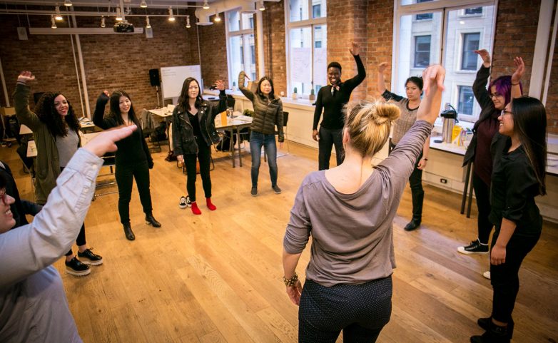 women talk design workshop stretching during a warm up exercise
