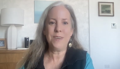 Middle aged, smiling Caucasian woman with long gray and blonde hair wearing a black vest over a turquoise sweater