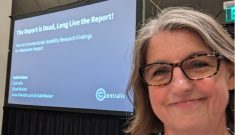 The presenter standing in front of the slides projected on a screen