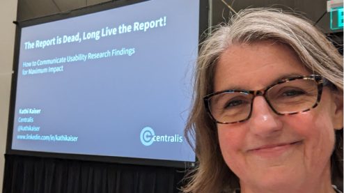 The presenter standing in front of the slides projected on a screen