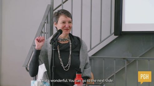 Hanna close up speaking at a podium for a creativemornings event