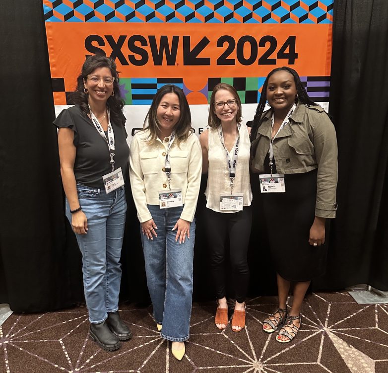 Four WTD speakers wearing SXSW neck lanyards standing under a SXSW2024 banner.